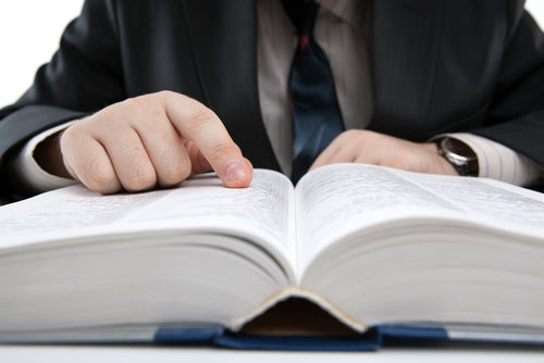 Man looking up data in law book.