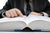 Man looking up data in law book.